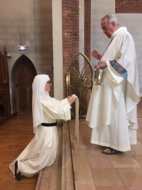 Sœur dominicaine prononçant ses vœux devant le célébrant