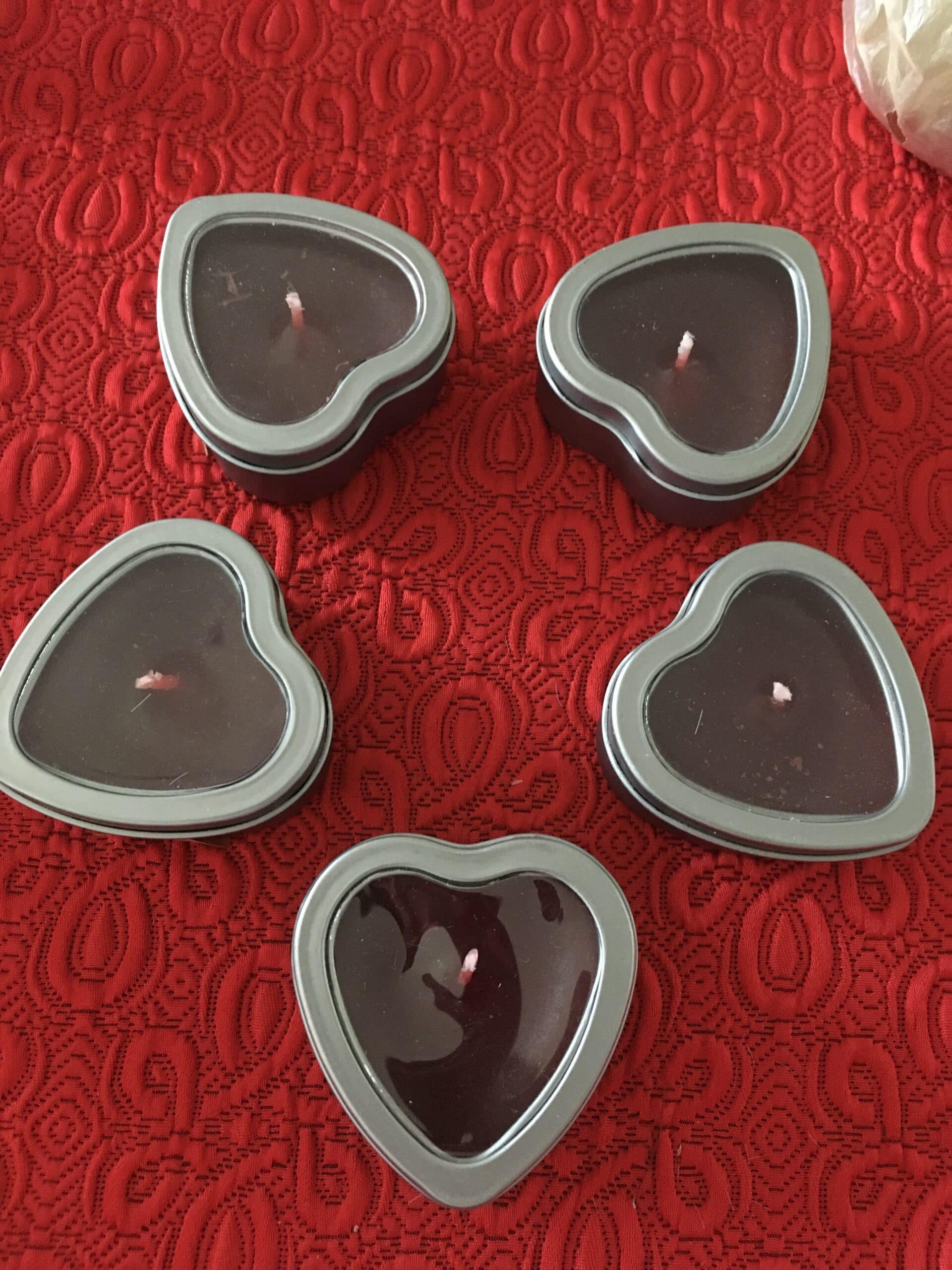Bougies en forme de cœur dans des boîtes métalliques