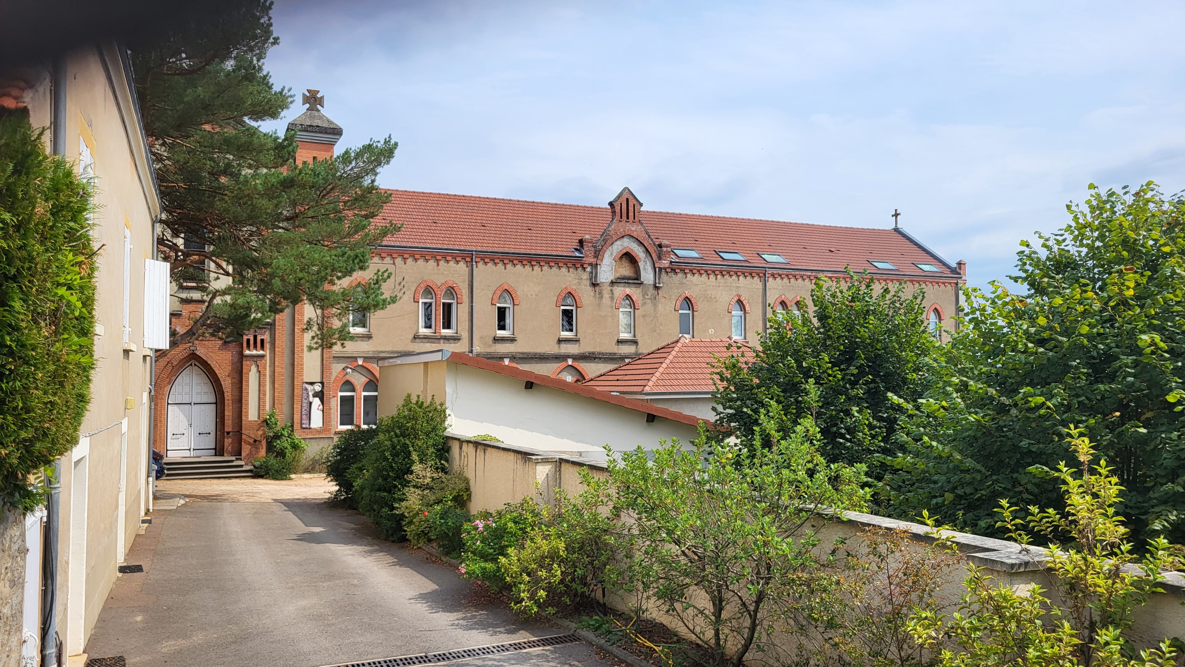L’entrée du monastère depuis l’avenue de Charolles, bâtiment de briques aux toits rouges